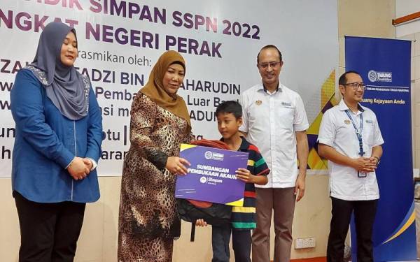 Puteri Holijah (dua kiri) menyampaikan replika kad sumbangan akaun Simpan SSPN Prime kepada pelajar asnaf yang hadir pada Program Didik Simpan SSPN 2022 Peringkat Negeri Perak.