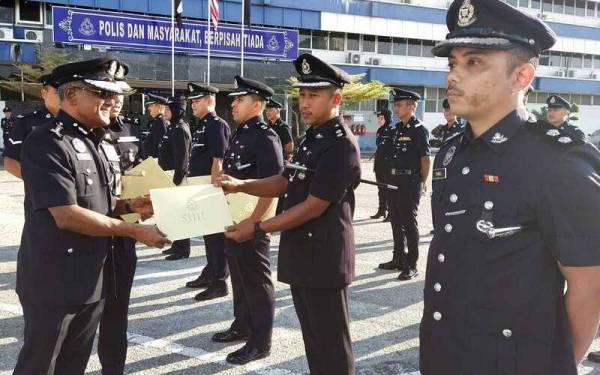 Ramli (kiri) menyampaikan Sijil Penghargaan Ketua Polis Pahang kepada penerima sempena Majlis Perhimpunan Bulanan di IPK Pahang di Kuantan pada Selasa.