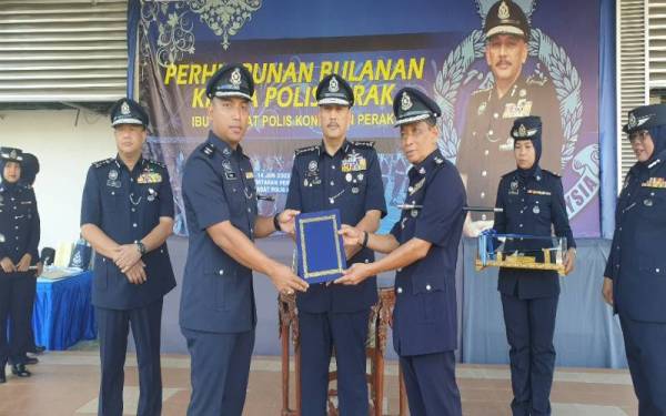 Mior Faridalathrash (tengah) menyaksikan penyerahan dokumen serah terima tugas jawatan Ketua Polis Daerah Muallim antara Kidam (kanan) kepada Mohd Hasni (dua dari kiri) pada Majlis Perhimpunan Bulanan Ketua Polis Perak Jun 2022 di IPK Perak pada Selasa.