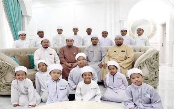 Murid-murid Akademi Tahfiz Masjid Aman (ATMA) di Cherang, Kota Bharu bergambar bersama barisan tenaga pengajar akademi berkenaan.