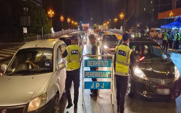 Pegawai JPJ menjalankan pemeriksaan kenderaan pada Op Pengarah JPJ Perak di Jalan Sultan Idris Shah di Ipoh.