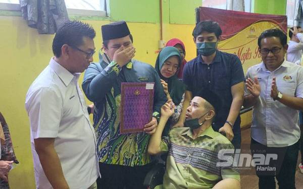 Ahmad Nabil disaksikan bapanya yang menghidap strok ketika menerima sijil pelajar cemerlang SPM 2021 yang disampaikan Mohamad dalam Majlis Pengumuman Keputusan SPM Tahun 2021 di SMK Agama Kota Kinabalu.