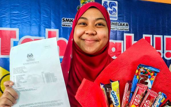 Nur Syafiqah menunjukkan keputusan SPM di SMK Bukit Rambai, Melaka pada Rabu.