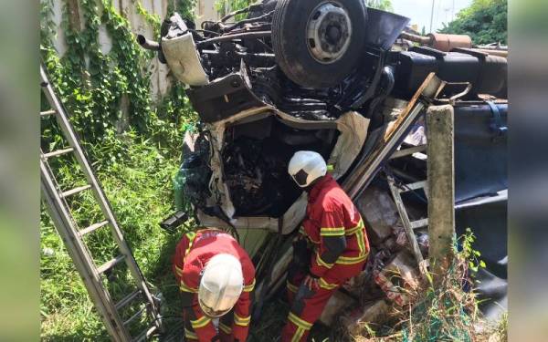 Bomba mengeluarkan mangsa yang tersepit selepas kenderaan dipandunya terjatuh ke dalam cerun di Lebuhraya Utara Selatan pada Khamis.