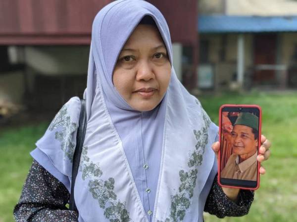 Hamidah menunjukkan gambar ayahnya yang hilang sejak 10 tahun lalu.