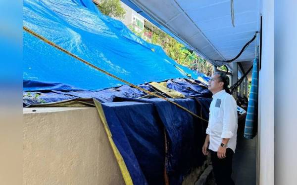 Fahmi meninjau keadaan tanah yang runtuh dalam kejadian enam bulan lalu di Lorong Travers yang belum dibaiki sehingga kini.