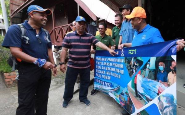 Ahli Dewan Undangan Negeri (ADUN) Tioman, Datuk Seri Mohd Johari Hussain (dua dari kiri) dan Zulkhairi (kanan) pada program pemantapan dan penyelarasan pengagihan bekalan makanan PDM-JKM bersama inter agensi di Pulau Tioman pada Sabtu.