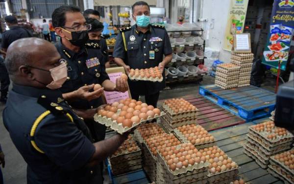 Azman (dua dari kiri) ketika melakukan pemeriksaan barangan keperluan harian di peringkat borong dan runcit di sebuah premis perniagaan di Bukit Mertajam hari ini.   - Foto Bernama