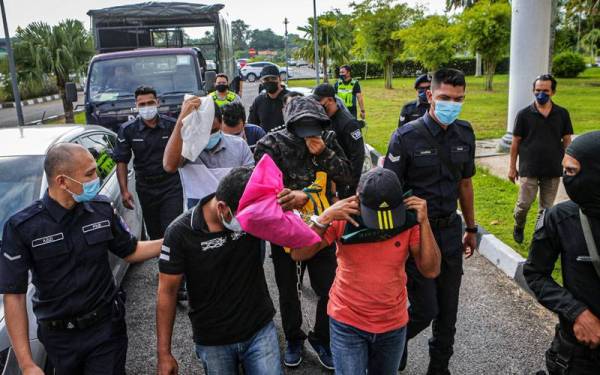 Tertuduh diirringi polis tiba di pekarangan Mahkamah Alor Setar di sini pada Isnin.