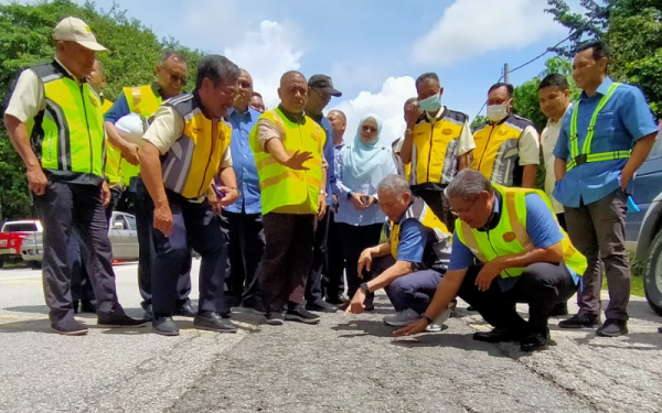 Fadillah (duduk, kiri) bersama Saarani (berdiri, empat dari kiri) ketika meninjau keadaan jalan di FT004 JRTB Gerik-Jeli selepas Taklimat Lawatan Kerja Ke Laluan Persekutuan di Daerah Hulu Perak, di sini pada Isnin.