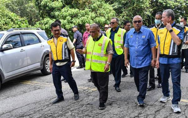 Saarani (dua dari kiri) bersama Fadillah (kanan) meninjau keadaan jalan Persekutuan yang rosak ketika lawatan kerja di Jalan Gerik- Jeli pada Isnin. - Foto Bernama