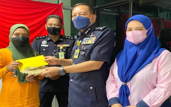 Rohaya (kiri) menerima kurniaan daripada Raja Perempuan Tengku Anis yang disampaikan oleh Muhamad Zaki (dua dari kanan) dan Suzana (kanan) di HRPZ II, Kota Bharu pada Rabu.