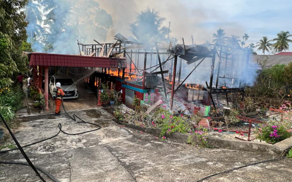 Anggota bomba melakukan kerja-kerja pemadaman kebakaran rumah dihuni empat sekeluarga di Felda Jengka 10, Maran pada Khamis.