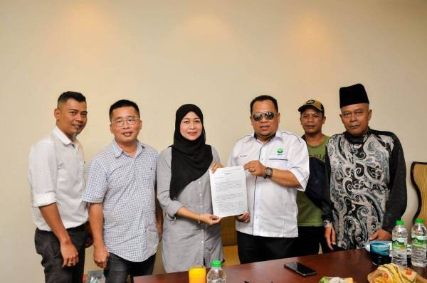 Zuhairi (tiga dari kanan) menunjukkan perjanjian kerjasama strategik antara Pertubuhan Perusahaan Pertanian Negeri Pahang (PPNP) dan NNTQ Agri Sdn. Bhd di Kuantan pada Khamis.