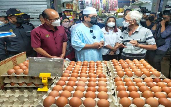 Norena (empat,kiri) ketika mengiringi Sulaiman menyantuni peniaga runcit di Pasar Awam Bachang, di sini, pada Jumaat.