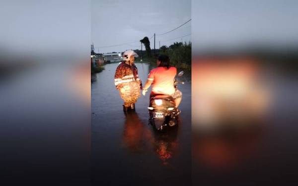 Anggota bomba sedang menjalankan tugas di kawasan yang dilanda banjir sekitar Telok Gong, Klang pada Jumaat.