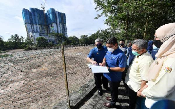 Mohd Radzi (dua dari kiri) melihat tapak projek semasa hadir ke Majlis Pecah Tanah Projek Pembinaan Bangunan Tambahan dan Padang Sekolah Kebangsaan Putrajaya Presint 18(2) pada Sabtu. - Foto Bernama