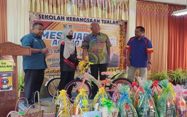 Mahdzir (dua dari kanan) menyampaikan hadiah cabutan bertuah kepada seorang waris pada perasmian Mesyuarat Agung Persatuan Ibu Bapa dan Guru (PIBG) Sekolah Kebangsaan Tualak, Kuala Nerang pada Sabtu.