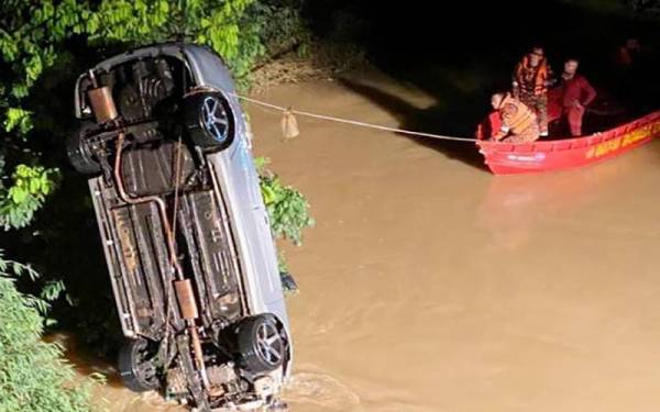 Bomba mengambil masa hampir 10 minit untuk menaikkan kereta mangsa yang terbabas dan terjunam ke dalam sungai, dengan menggunakan kren. - Foto Astro Awani