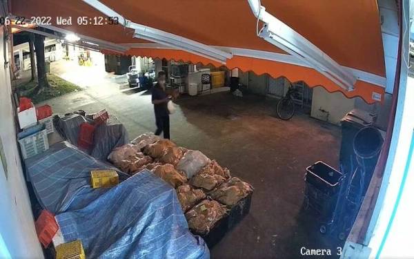 Rakaman CCTV HoJiak Durian and Fruits menunjukkan seorang lelaki yang mencuri durian di sebuah kedai buah itu di Singapura. - Foto HoJiak Durian and Fruits/MSNews