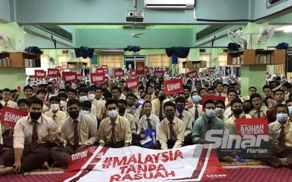 Pelajar bergambar bersama plakad antirasuah ketika menerima kunjungan Konvoi #RasuahBusters ke MRSM Kuantan, pada Isnin.