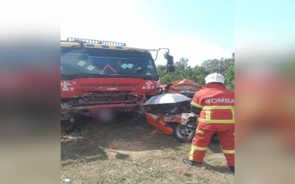 Anggota bomba membantu mengeluarkan mayat mangsa yang tersepit selepas kereta dinaiki mereka terbabit kemalangan dengan sebuah treler di Jalan Gambang-Muadzam Shah dekat Kampung Pulau Manis, pada Selasa.