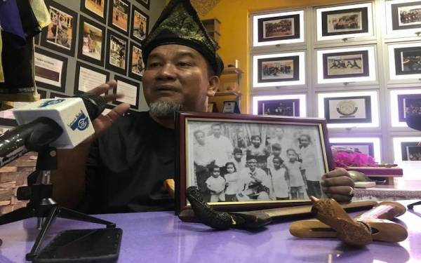 Mohd Alhamadi menunjukkan gambar kenangannya bersama Mat Kilau ketika berusia lima tahun.