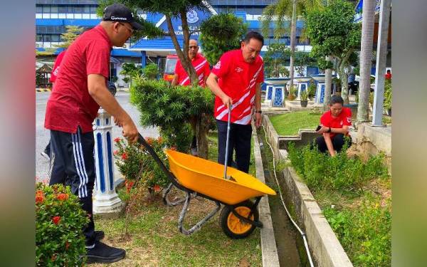 Muhamad Zaki (dua dari kiri) turut serta bergotong-royong pada Majlis Gotong-Royong Mega 1.0 Perangi Aedes Peringkat Kontinjen Kelantan di IPK pada Khamis.