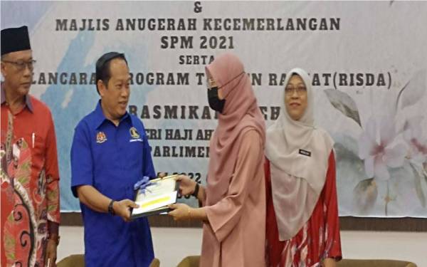 Ahmad menyerahkan sijil dan sumbangan kepada pelajar cemerlang SPM Parlimen Pontian di SMK Parit Betak pada Jumaat.