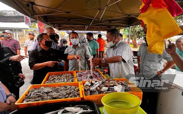 Ahmad meninjau barangan yang dijual pada program JTDLKM di Ibu Pejabat FAMA pada Jumaat.