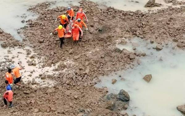 Anggota Pasukan Tindak Balas Bencana Negara menemui seorang lagi mangsa dari tanah runtuh. - Foto AP