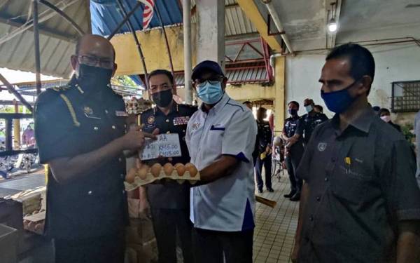 Azman (dua dari kiri) dan Azman (kiri) semasa pemeriksaan penguatkuasaan sempena pelaksanaan penentuan harga maksimum ayam dan telur di Pasar Besar Alor Setar pada Sabtu.