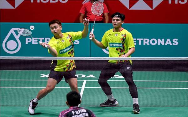 Sze Fei (kiri) dan Izzuddin beraksi ketika menentang Fajar Alfian-Muhammad Rian pada perlawanan separuh akhir Terbuka Malaysia di Axiata Arena Bukit Jalil, pada Sabtu. - Foto Bernama