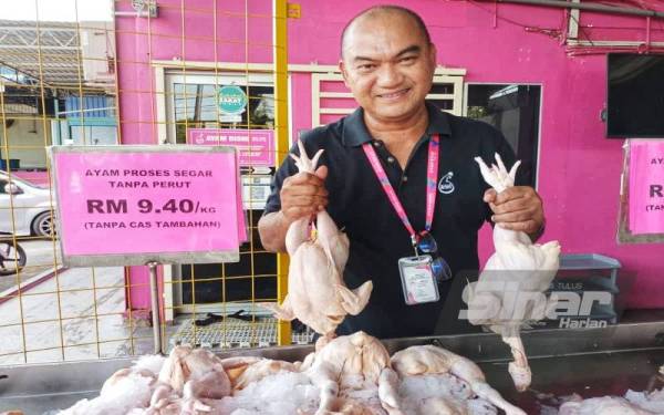 Pengurus Besar Ayam Bismi, Azli Saat menunjukkan ayam segar berharga RM9.40 sekilogram yang dijual di pusat jualan mereka.