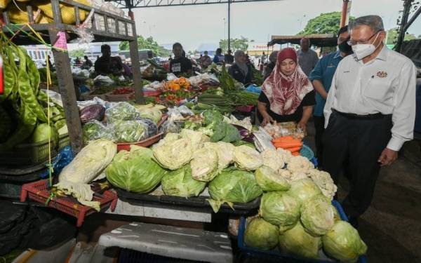 Mustapa M(kanan) bertanyakan sesuatu kepada salah seorang peniaga semasa beliau melakukan tinjauan harga barang keperluan harian dan runcit di Pusat Transformasi Luar Bandar (RTC), Tunjong pada Ahad. - Foto Bernama