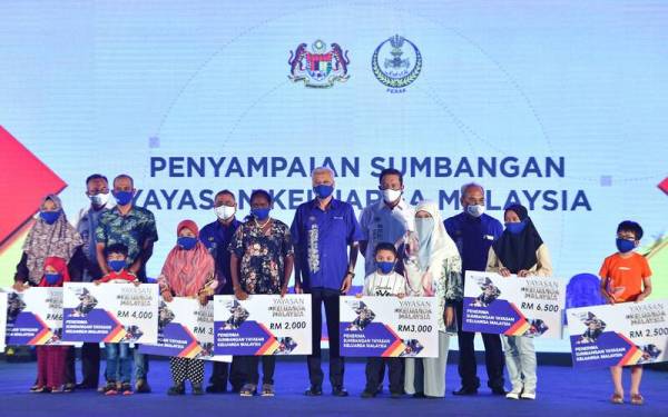 Ismail Sabri (tengah) bergambar bersama penerima sumbangan Yayasan Keluarga Malaysia pada majlis penutup Jelajah AKM di Litar Dato Sagor pada Ahad. - Foto Bernama