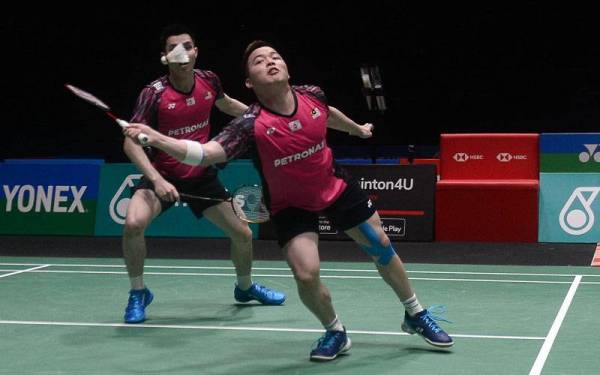 Aksi Aaron (kanan) dan Wooi Yik (kiri) sewaktu menentang pemain Jepun, Takuro Hoki dan Yugo Kobayashi pada perlawanan separuh akhir Kejohanan Petronas Terbuka Malaysia 2022 di Axiata Arena Bukit Jalil. - Foto Bernama