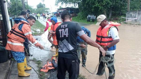 Anggota Angkatan Pertahanan Awam (APM) Baling sedang melakukan operasi membantu memindahkan mangsa banjir di Baling.