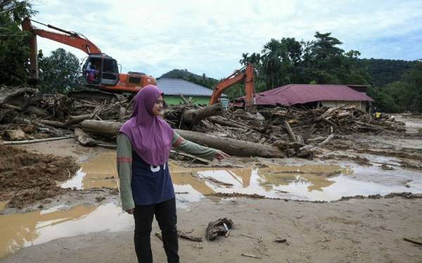 Pengusaha kedai bakeri Nurul Halimah Kuin, 29, menunjukkan tapak kedainya yang roboh akibat arus deras dan fenomena kepala air yang berlaku di Kampung Iboi Kupang petang semalam. -Foto Bernama