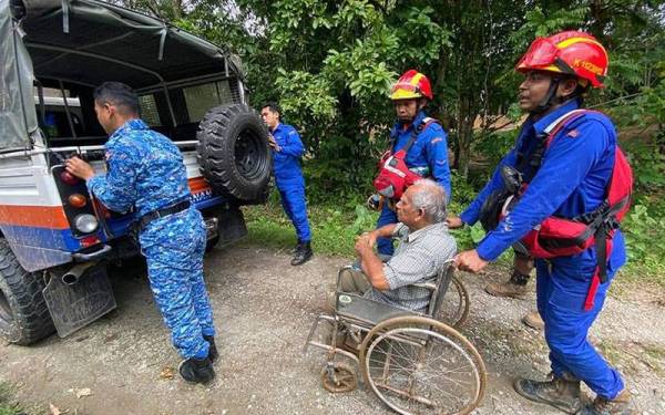 Anggota APM membantu memindahkan mangsa yang terlibat banjir ke tempat selamat selepas banjir dan kepala air pada Isnin. -Foto: Facebook APM Negeri Kedah