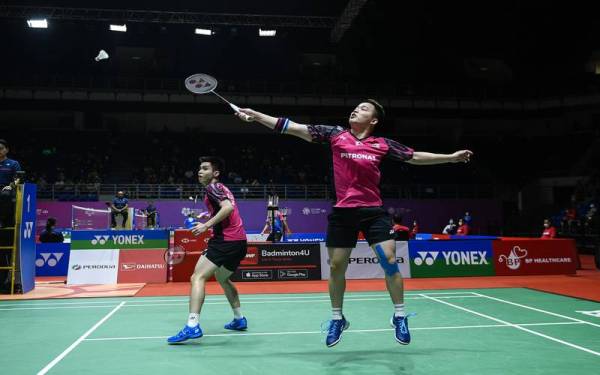 Aksi beregu badminton lelaki Malaysia, Soh Wooi Yik (kiri) dan Aaron Chia (kanan) ketika perlawanan menentang pemain Jepun, Akira Koga dan Taichi Saito pada perlawanan kelayakan Perodua Malaysia Masters di Axiata Arena Bukit Jalil pada Selasa. - Foto Bernama