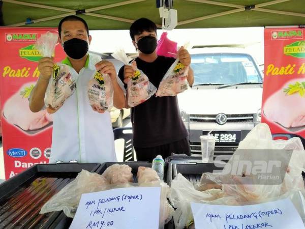 Hasnan (kiri) menunjukkan ayam super yang dijual pada harga RM9 seekor sempena Jualan Terus Dari Ladang Keluarga Malaysia Sempena Aidiladha di RTC Perak, pada Jumaat.