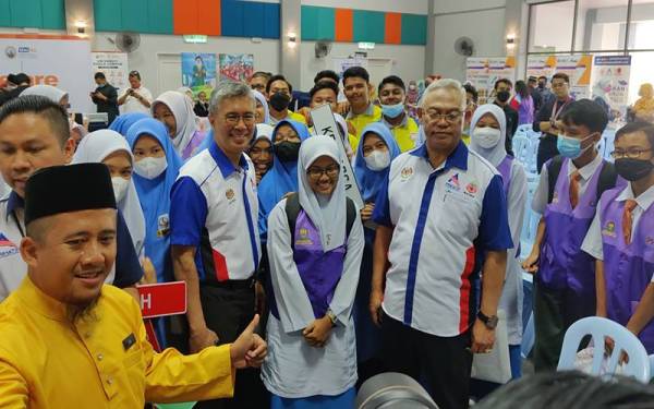 Tengku Zafrul (depan, tiga dari kanan) diiringi Menteri Pembangunan Usahawan dan Koperasi, Tan Sri Noh Omar bersama guru dan pelajar pada Program Jelajah Pendidikan Keluarga Malaysia di Dewan Dato' Penggawa Permatang pada Jumaat.