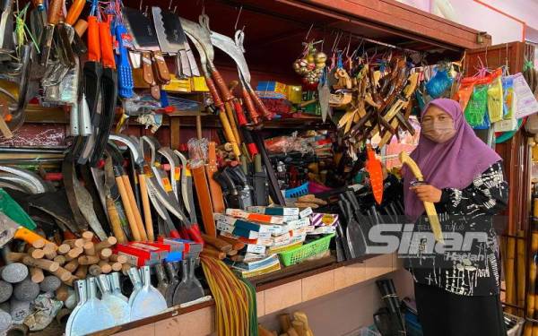 Faridah menunjukkan aneka jenis kelengkapan korban yang dijual di Pasar Siti Khadijah, Kota Bharu.