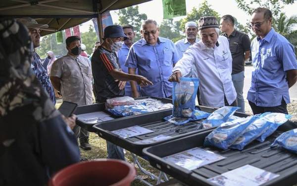 Zainal Abidin (tengah) ketika membuat lawatan ke gerai-gerai jualan pada Program Jualan Terus Dari Ladang Keluarga Malaysia di Medan Jaya, Marang pada Sabtu. -Foto Bernama