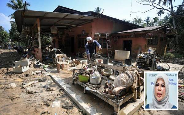 Salah seorang penduduk Kampung Hangus melihat barangan yang dipenuhi lumpur selepas rumahnya dinaiki air dalam kejadian banjir dan fenomena kepala air yang berlaku pada Isnin lepas di daerah ini. -Foto Bernama . (Gambar dalam : Rina)