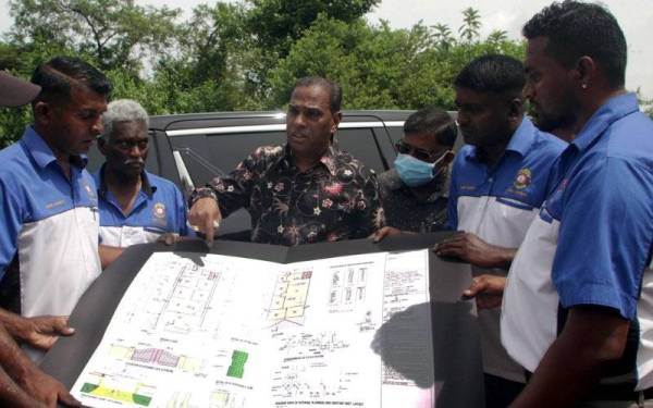 Saravanan (tiga, kiri) melihat pelan Rumah Kelab Bell Belia Tamil Gopeng selepas merasmikan majlis pecah tanahnya di Kampung Baru Kopisan pada Sabtu. - Foto Bernama 