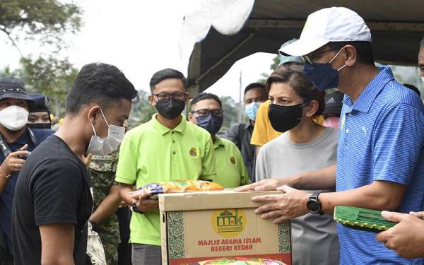 Tengku Sarafudin Badlishah bersama Raja Puan Muda Kedah Che Puan Muda Zaheeda menyampaikan sumbangan kepada mangsa banjir, Mohd Khairul Asyraf, 24, ketika berangkat meninjau lokasi kejadian jambatan runtuh di sini hari ini. Foto Bernama