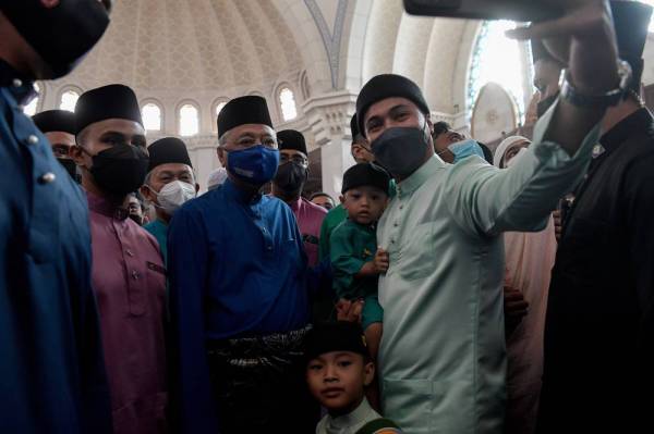 Ismail Sabri (tengah) beramah mesra bersama para jemaah selepas menunaikan solat sunat Aidiladha di Masjid Wilayah Persekutuan pada Ahad. -Foto Bernama