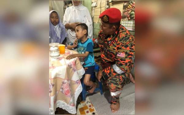 Seorang anggota bomba bersama Muhammad Fakhri (tengah) yang ditemukan selamat di kawasan hutan berhampiran rumahnya di Kampung Jawa Lanut, Tawau.